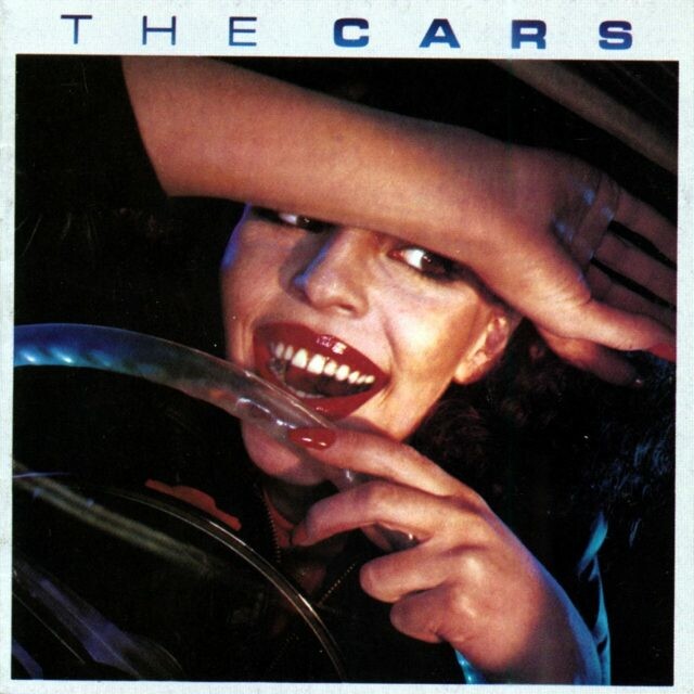 The Cars record cover -- a woman behind the wheel of a car with her left hand on the wheel and her right arm in front of her forehead