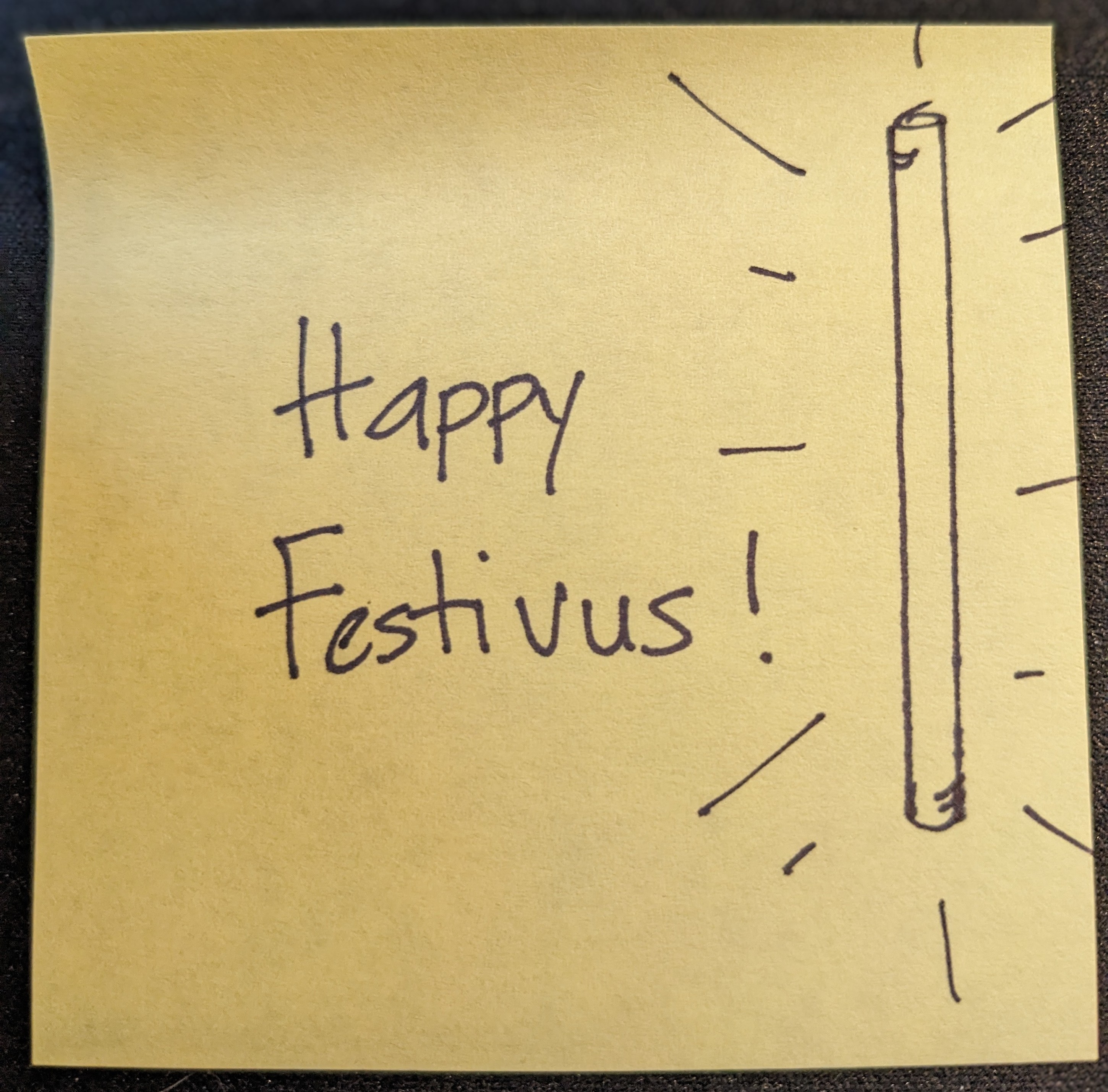 A Post-it note that says "Happy Festivus" and had an illustration of a pole on it