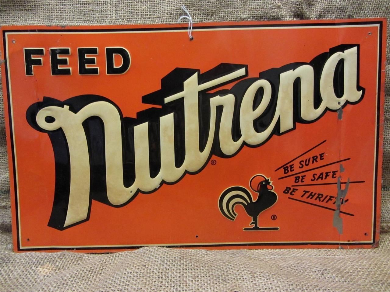 An orange metal sign for Nutrena feed. A rooster in the corner says, "Be sure, be safe, be thrifty"