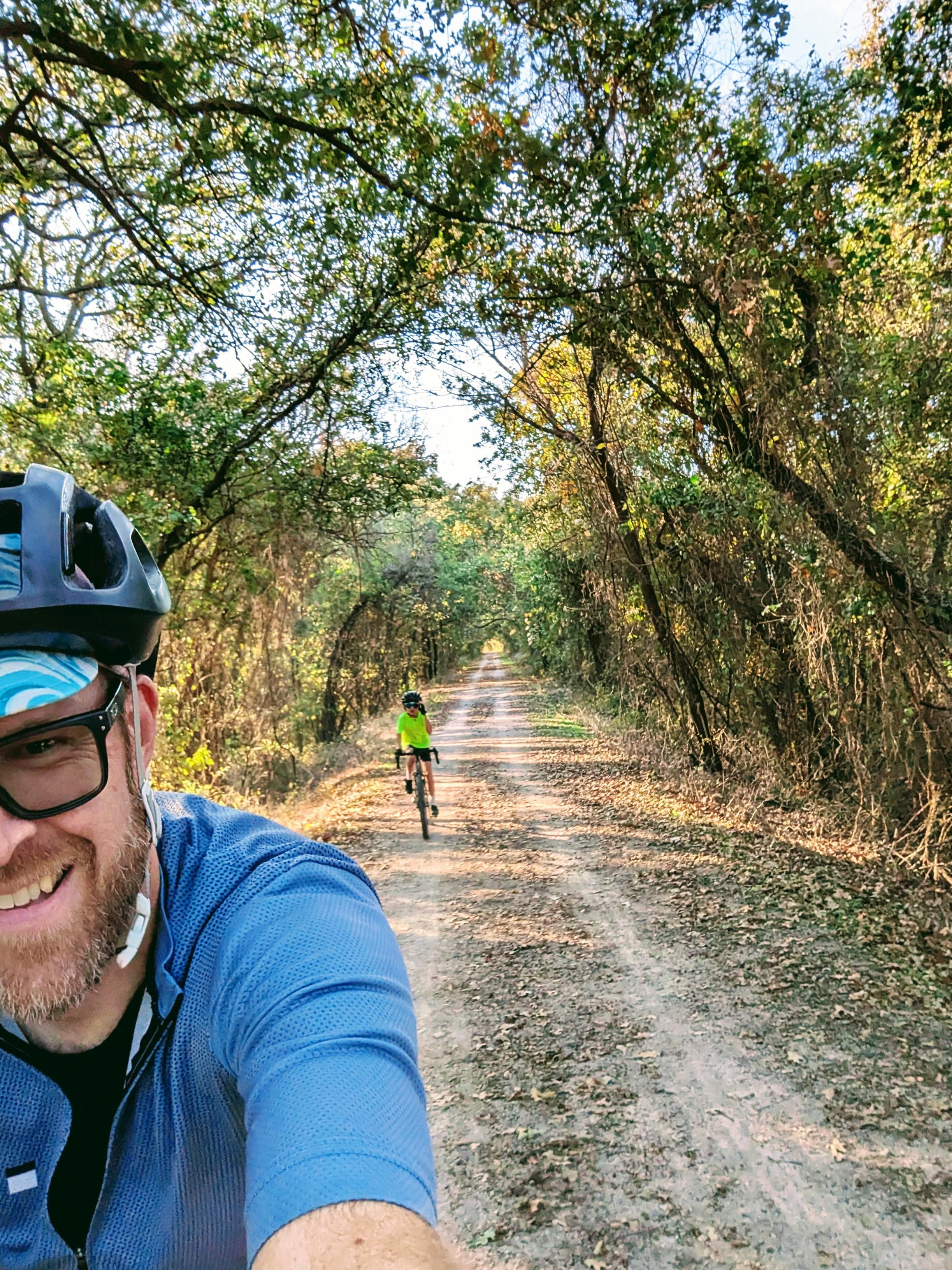 Selfie from the bike, boy behind me, the gravel trail straight to the vanishing point