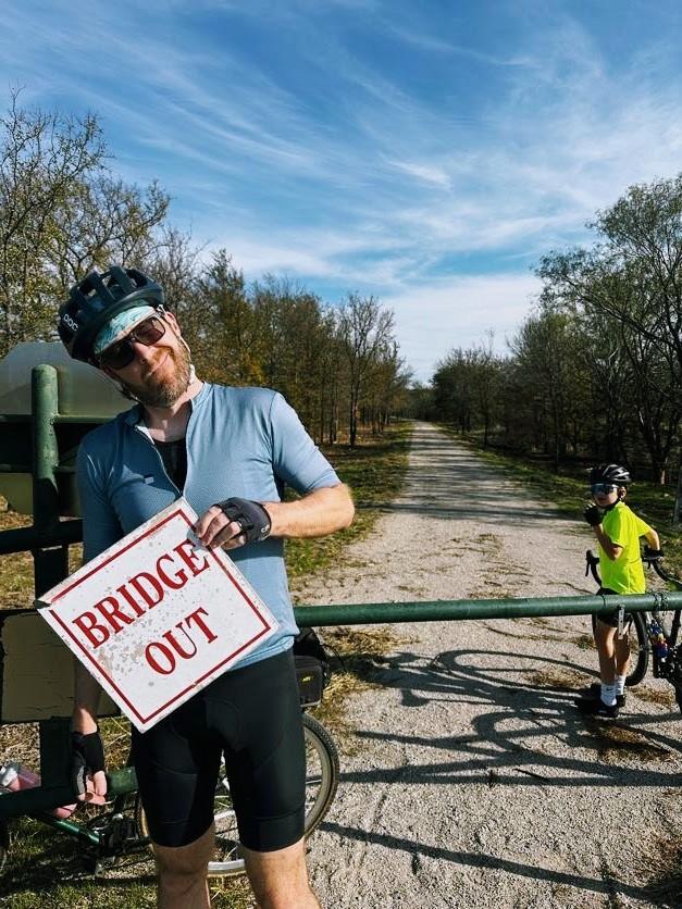 I'm holding a "bridge out" sign I found on the ground on the way back. I'm making a silly, bemused have