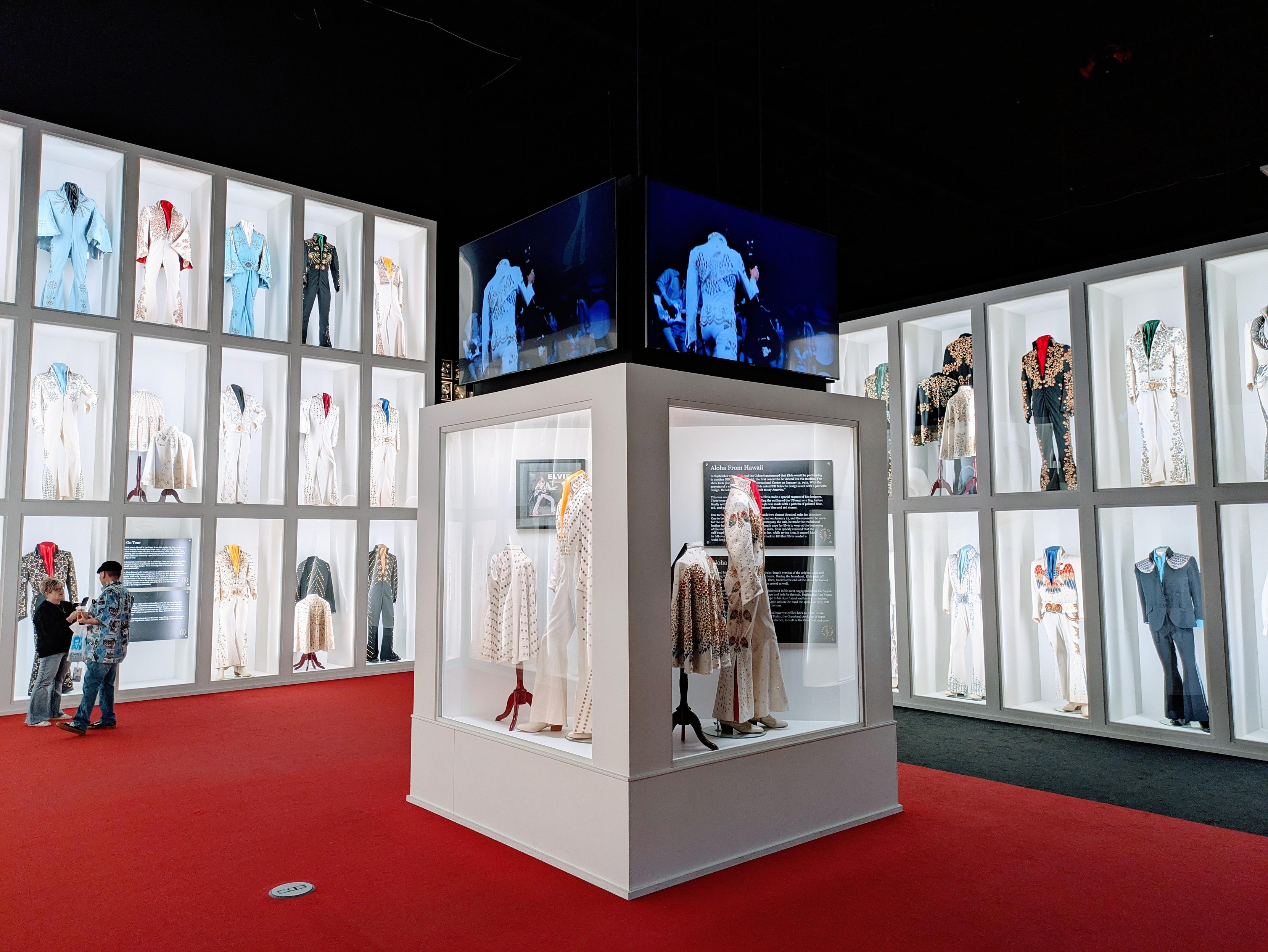 A photo of the room at Graceland containing Elvis' jumpsuits. It is a large room with 2- and 3-tall glass cases containing displays of jumpsuits 