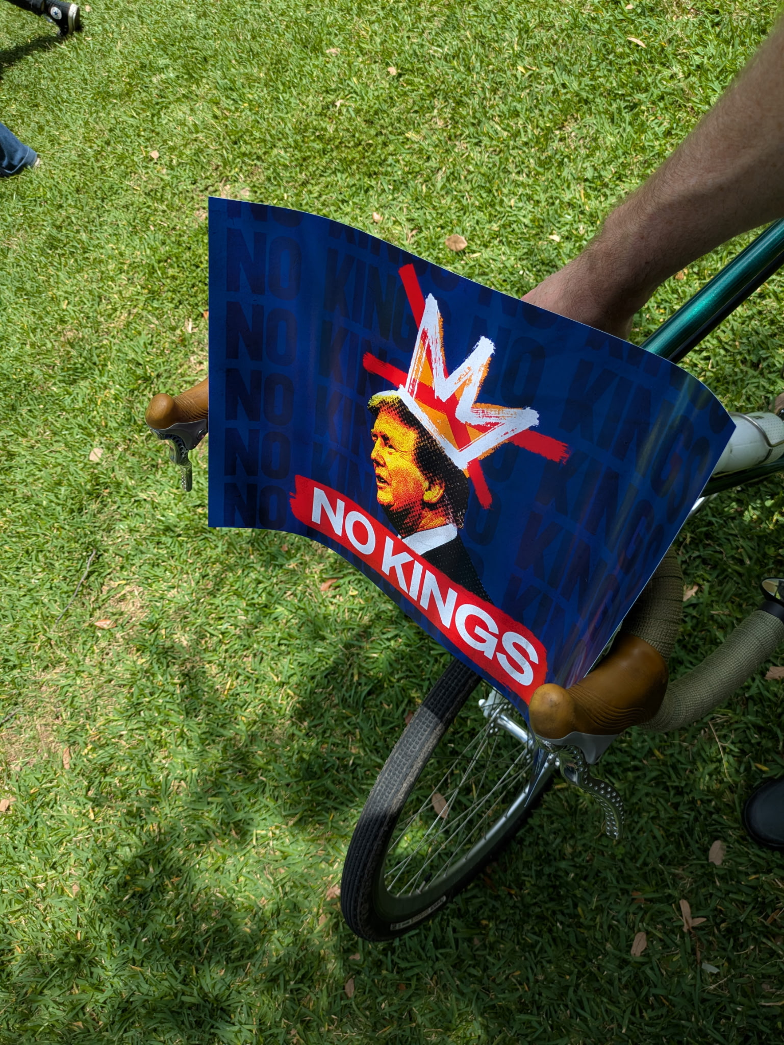A "No Kings" protest sign wedged within bicycle handlebars